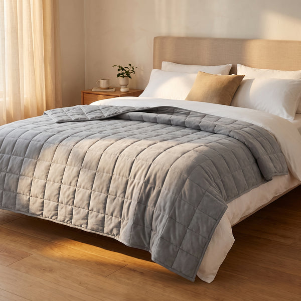 Couverture lestée Lestona, coloris gris, dépliée sur un lit dans une chambre