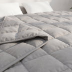 Couverture lestée Lestona, coloris gris, drapé et matelassage vus de près sur un lit
