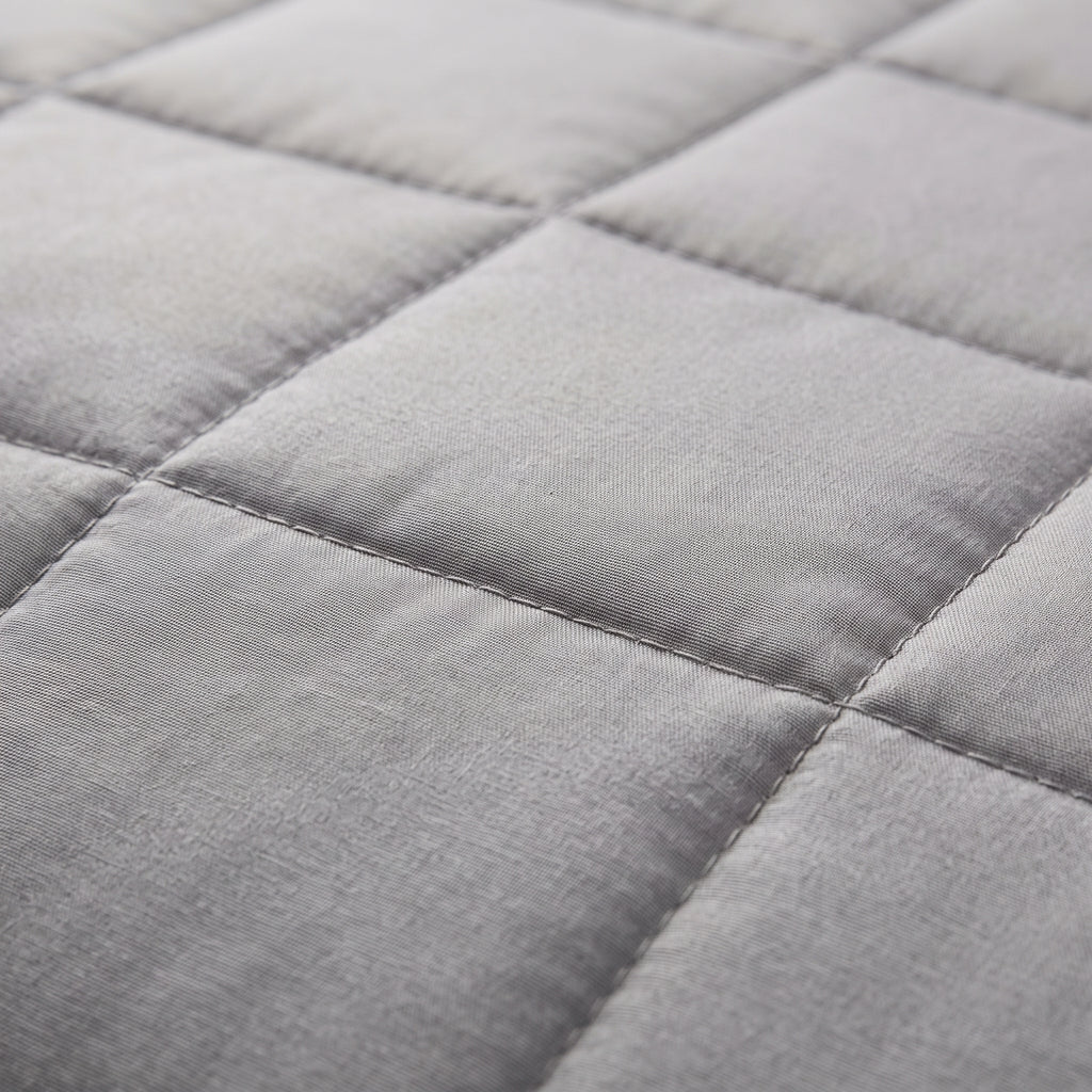 Couverture lestée Lestona, coloris gris, gros plan du tissu matelassé et des coutures