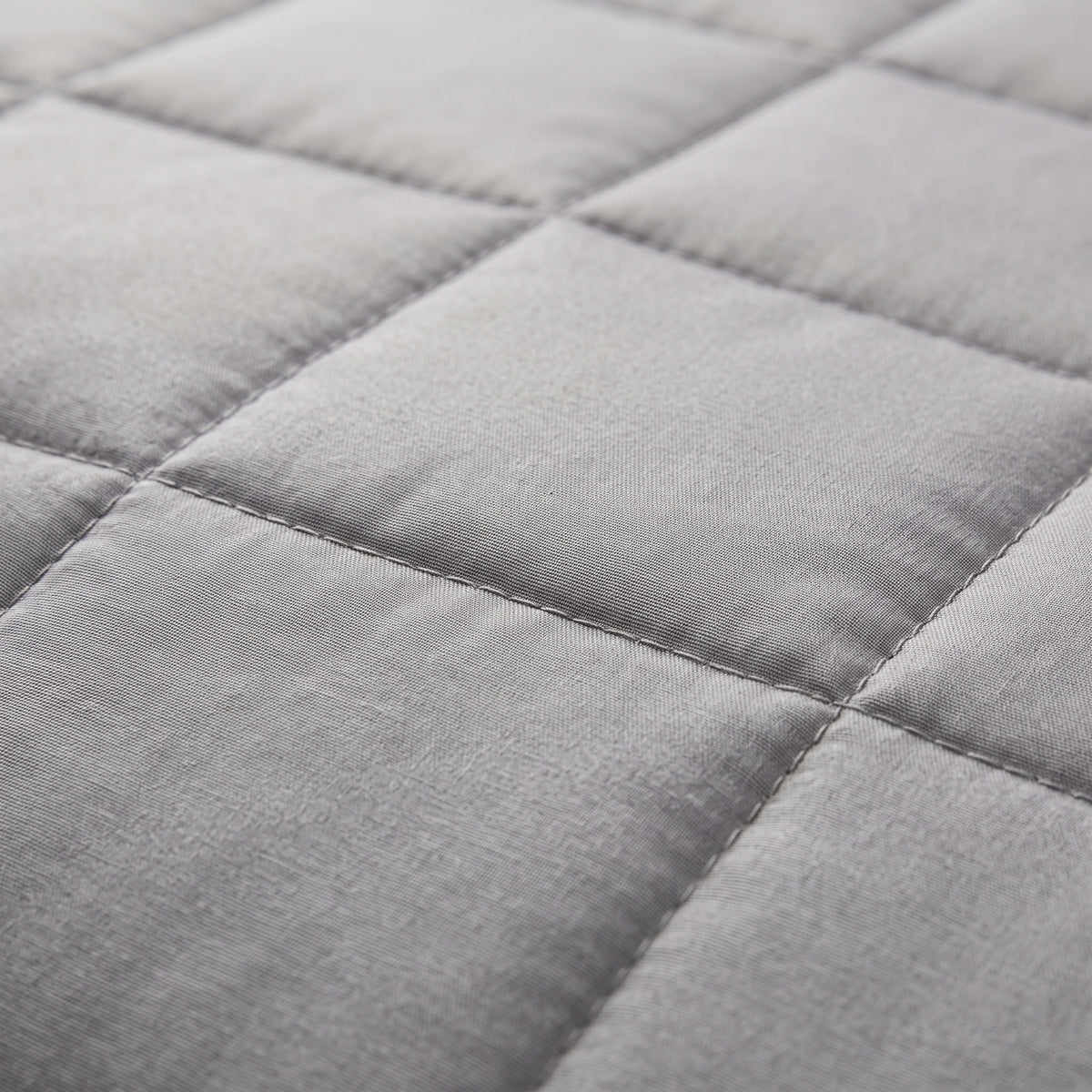 Couverture lestée Lestona, coloris gris, gros plan du tissu matelassé et des coutures